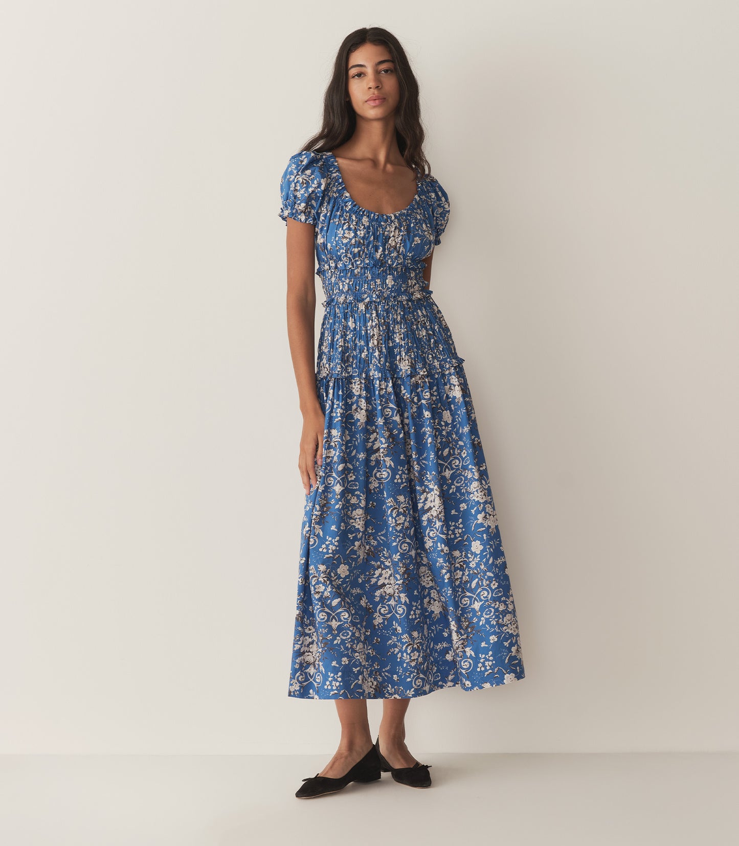 Rocio is wearing a long blue and white floral dress.